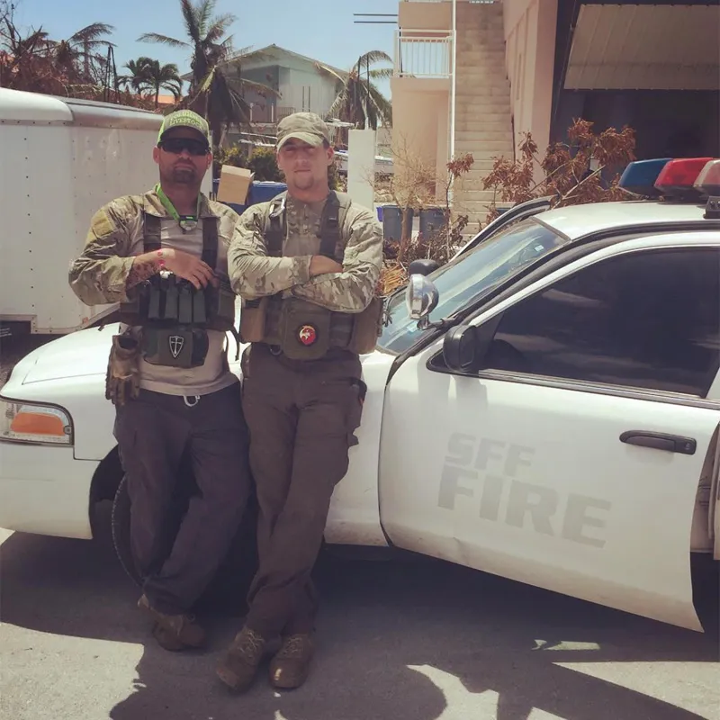 Two military people standing near the car