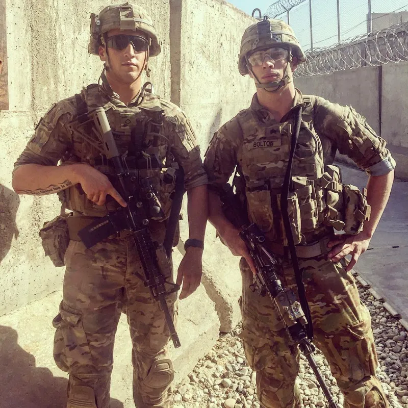 Two military people standing at the border with guns